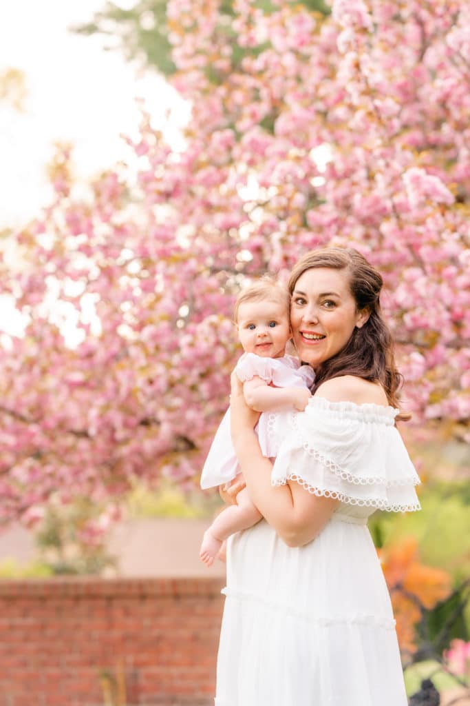 Mother and daughter in front of pink blooming cherry tree
