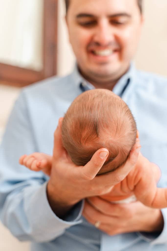 Father holding newborn boy, detail shot of baby's head of hair