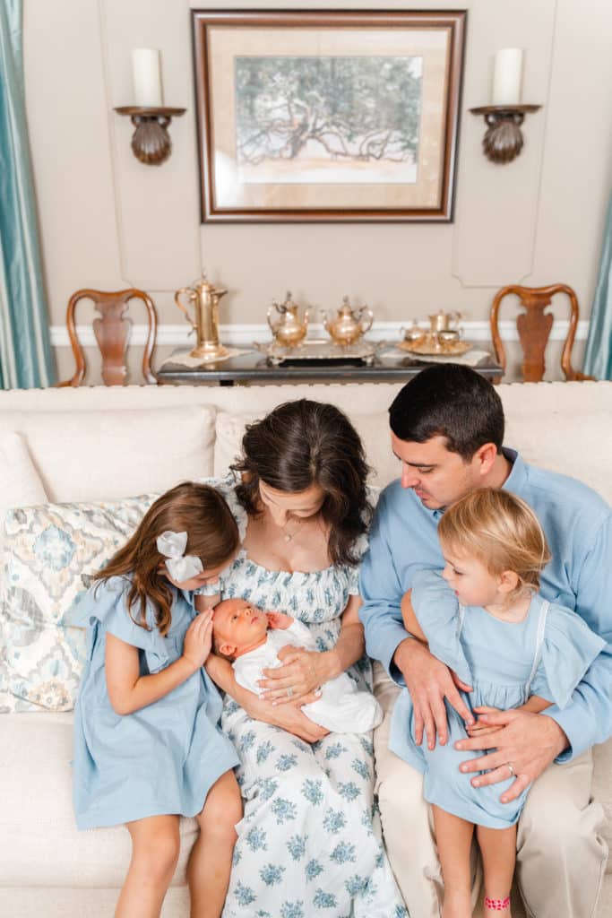 Family of 5 posing in living room during lifestyle newborn photography session