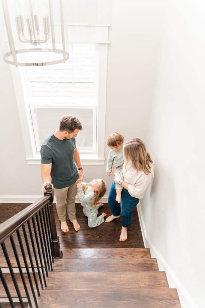 Family walking upstairs in home during lifestyle photography session