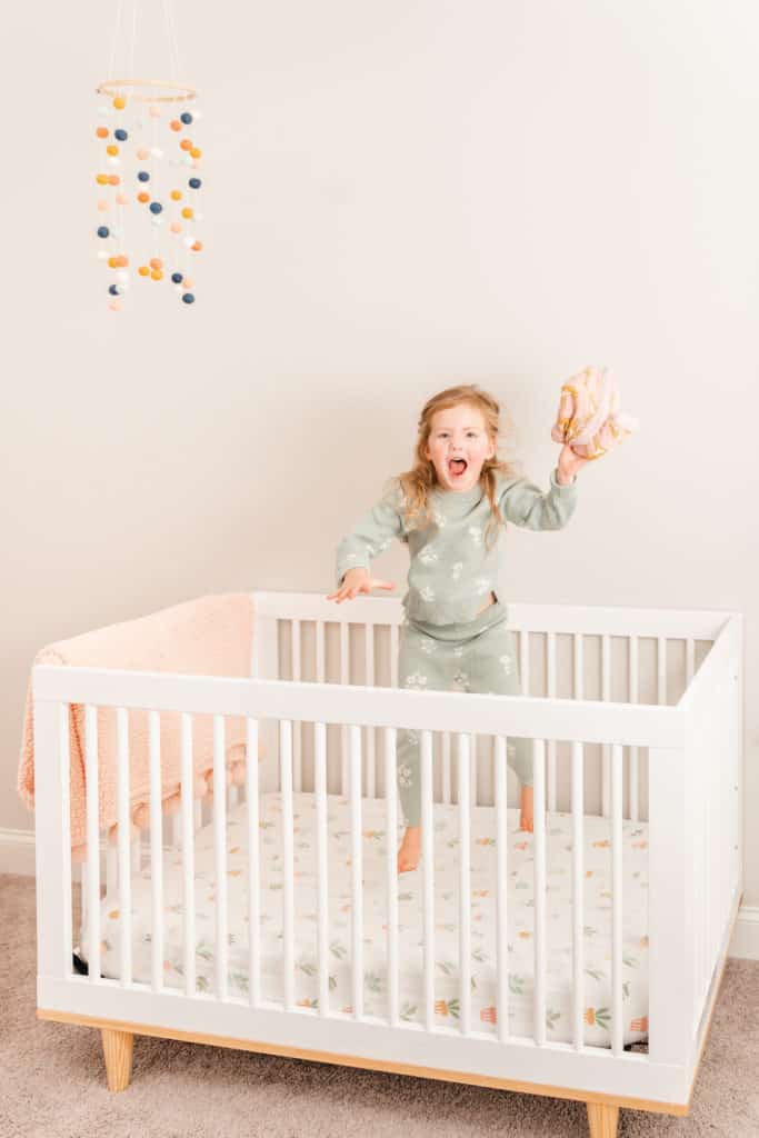 Portrait of girl jumping in crib using off camera flash