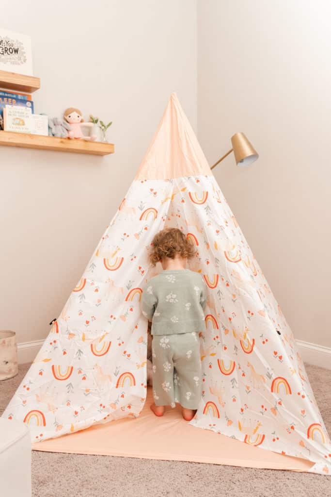 Toddler walking into tent in nursery