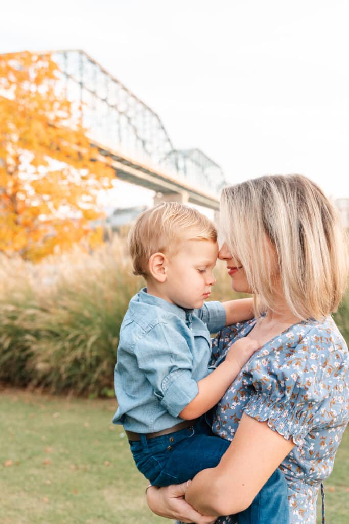 Mother snuggles baby during photoshoot at Coolidge Park in Chattanooga, TN.