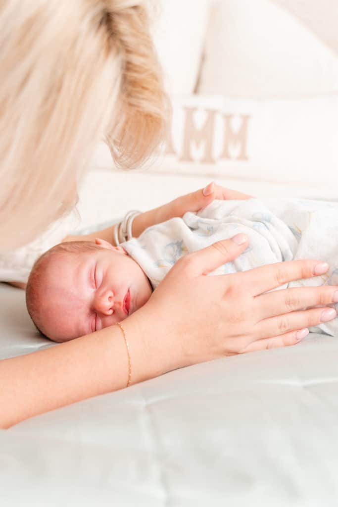 Mother cuddling newborn baby during light and airy Chattanooga newborn photography session.