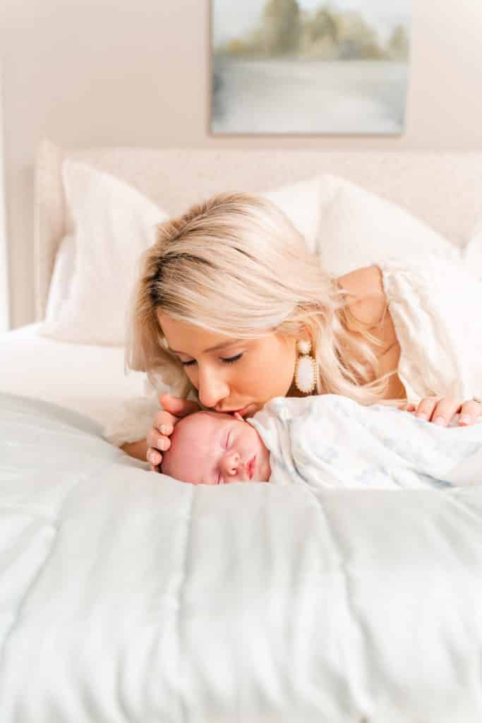Newborn photography session, mother posing with newborn baby boy kissing cheek