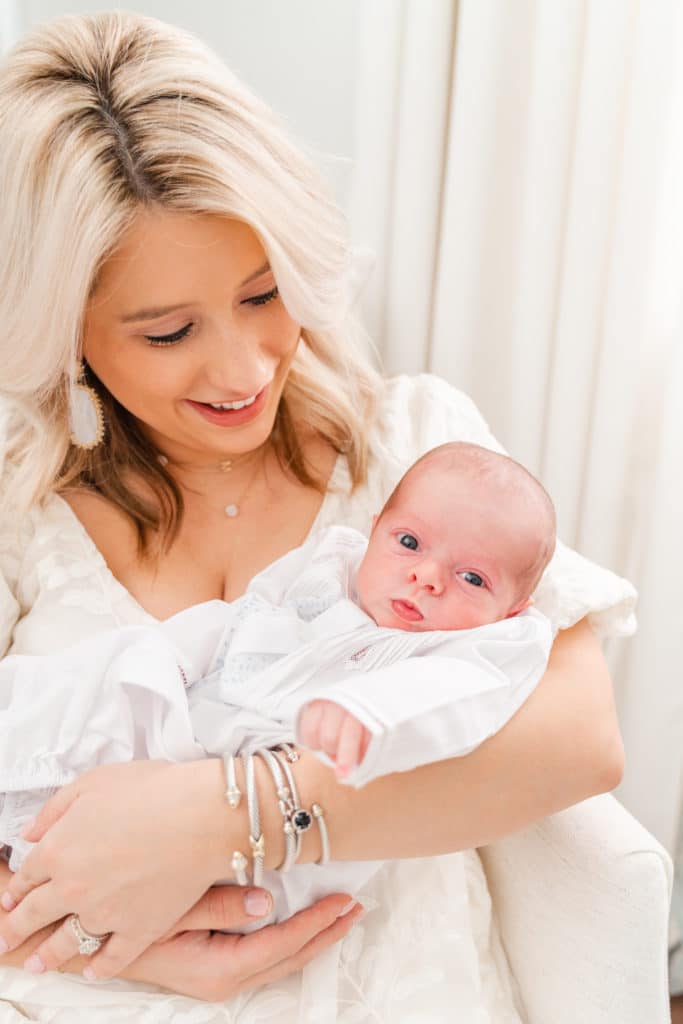 Crisp, white, bright newborn photography session, mother holding awake newborn boy