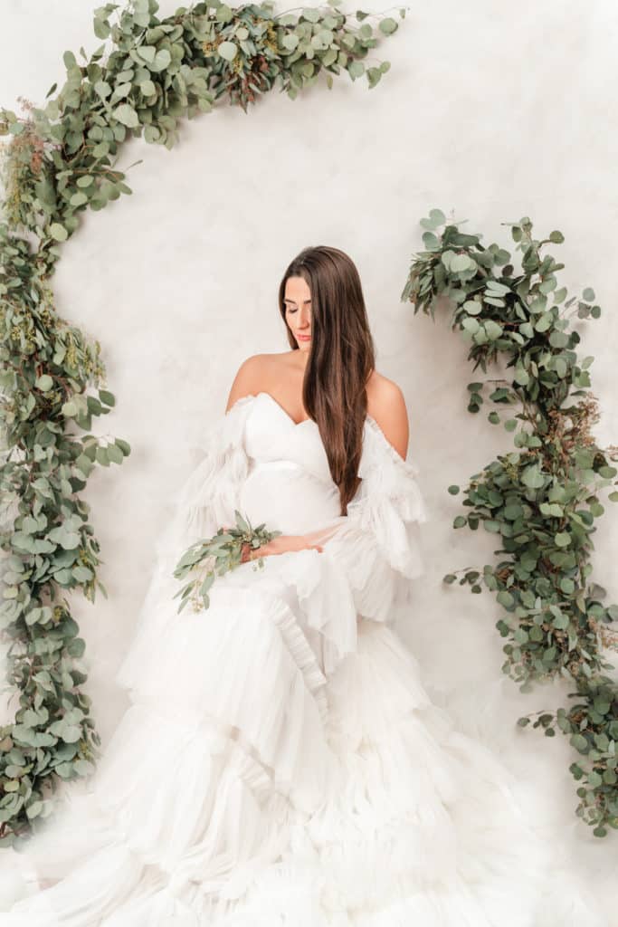 Eucalyptus style maternity photography session with hand painted backdrop and luxury white tulle gown