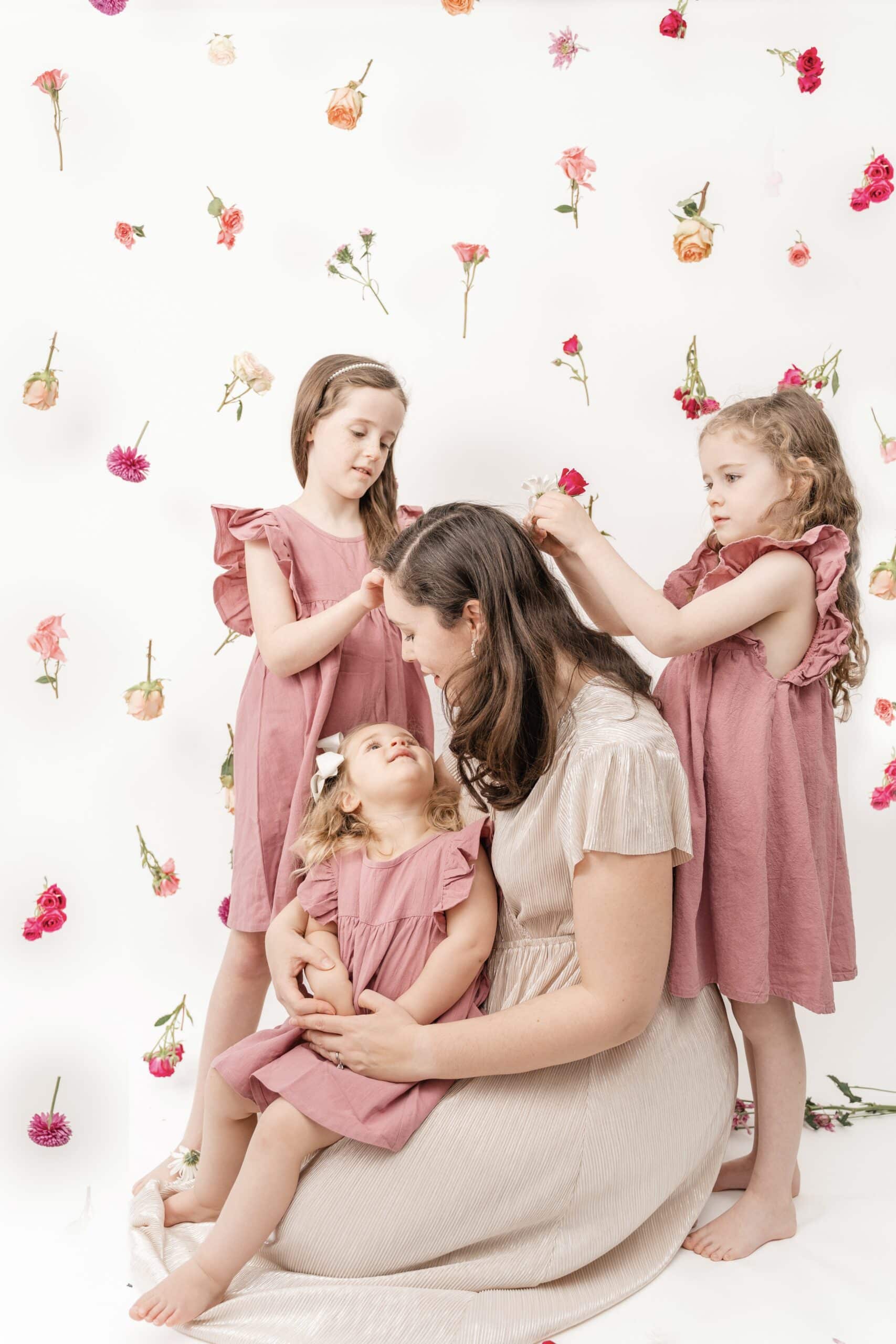Girls playing with mother's hair during hanging flower Valentine's photoshoot.