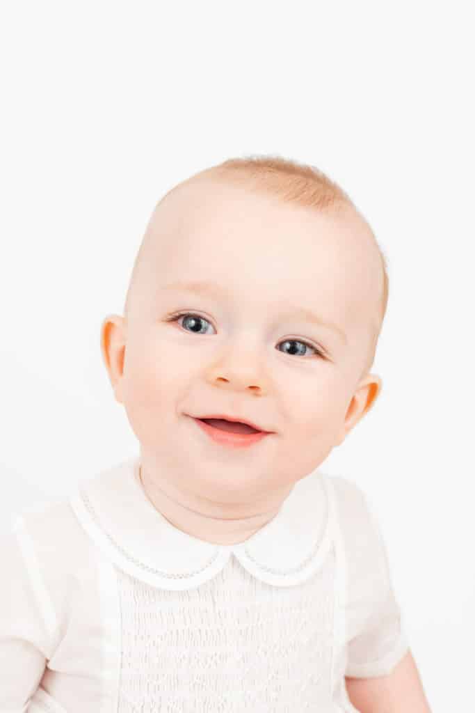 Baby boy smiling in front of white backdrop during Chattanooga traditional children's portrait