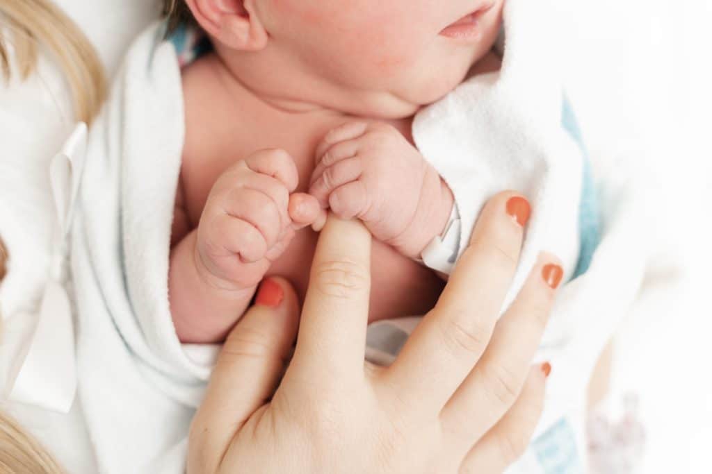 Newborn baby clutching mother's finger during Chattanooga Fresh 48 session