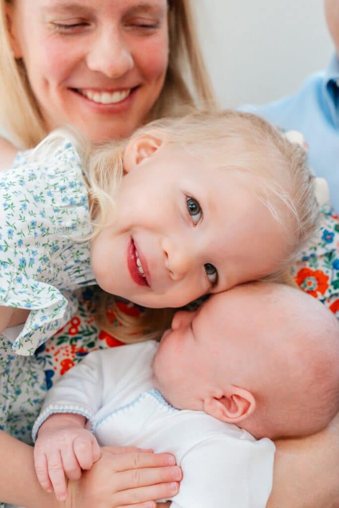 big sister cuddles little brother. Image in post about how to display newborn photos. 
