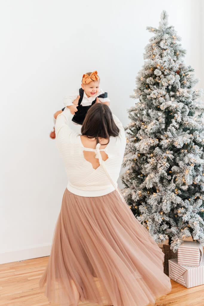 Mom twirling with baby girl wearing sweater and tulle skirt from Chattanooga boutque