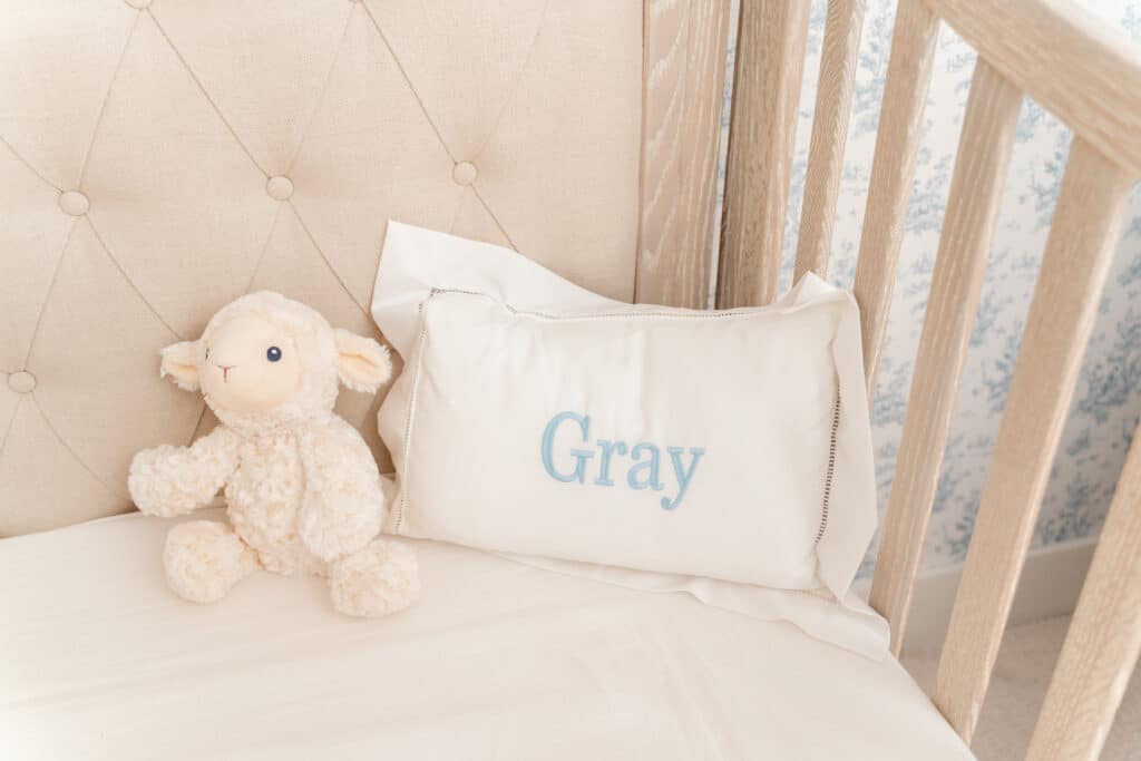 Detail image of stuffed animal and pillow in baby boy's nursery