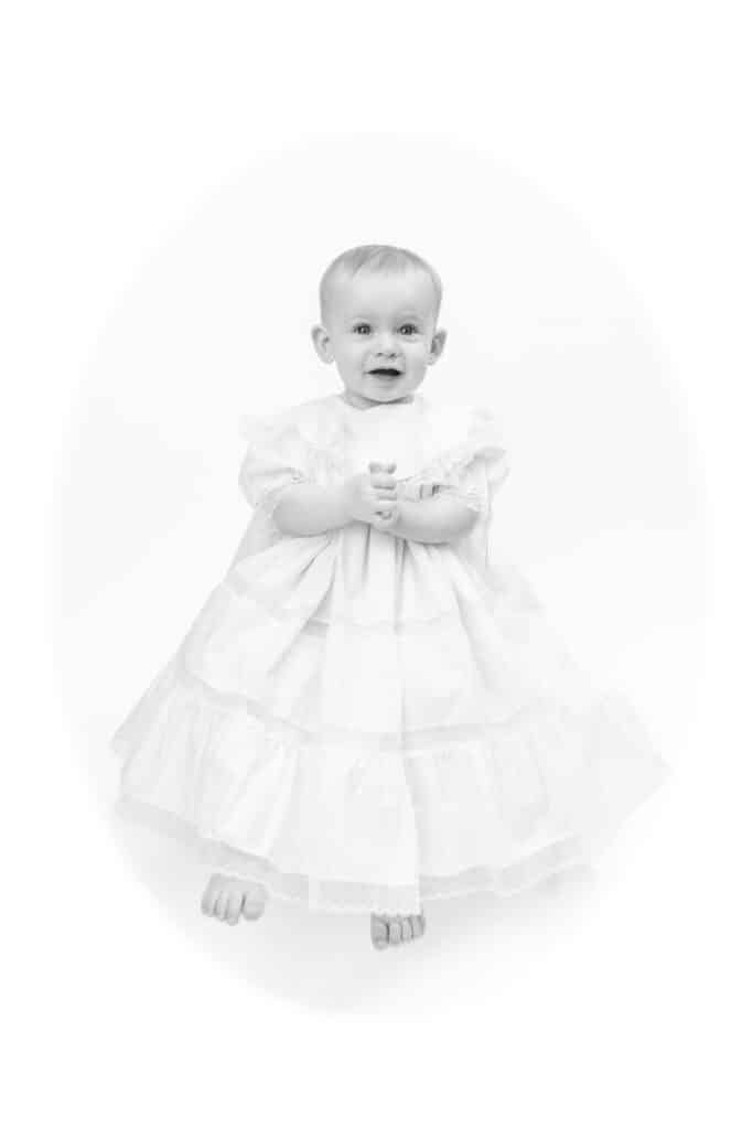 Classic black and white vignette portrait of little girl in gown. 