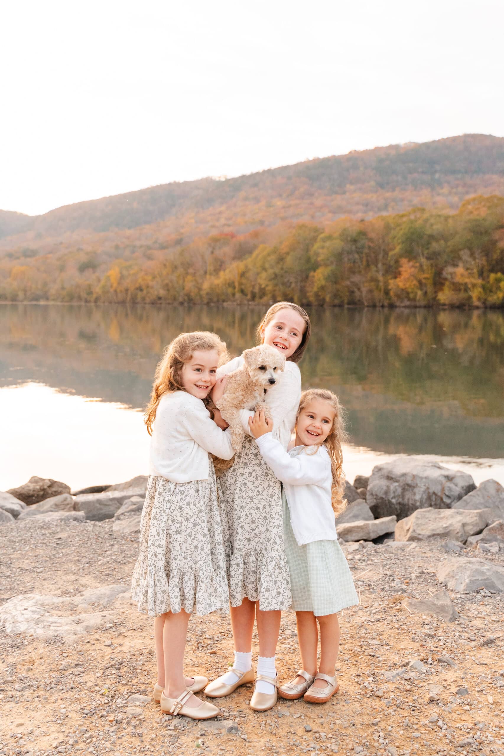 Wanting to learn how to take better photos of your family? Image of three daughters and puppy taking by mom photographer Kelley Hoagland