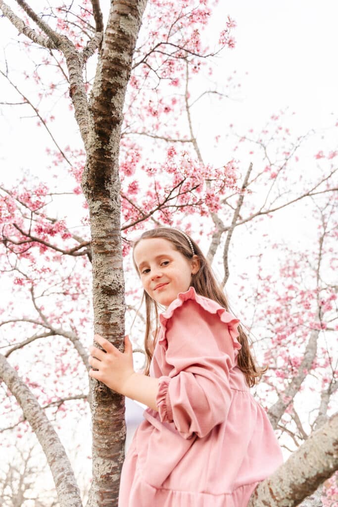 Portrait of girl sitting in blooming cherry tree taken using custom white balance set by ExpoDisc v3