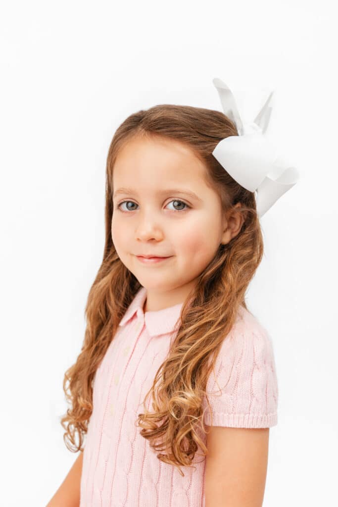 little girl wears pink dress to in heirloom photos.